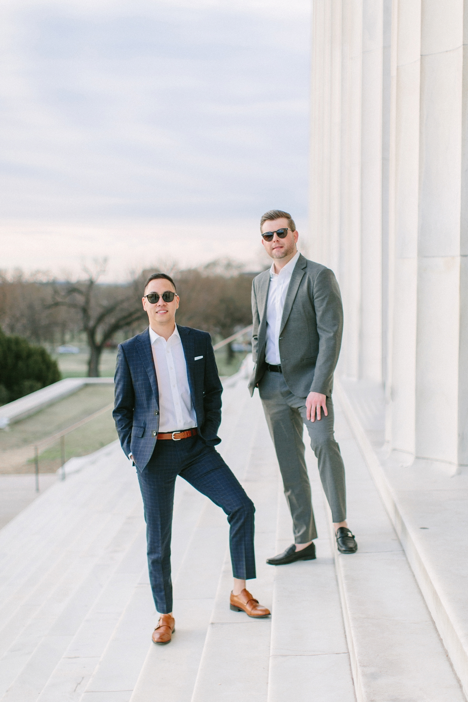 Gay couple wearing suits and sunglasses at their engagement session at the Lincoln Memorial