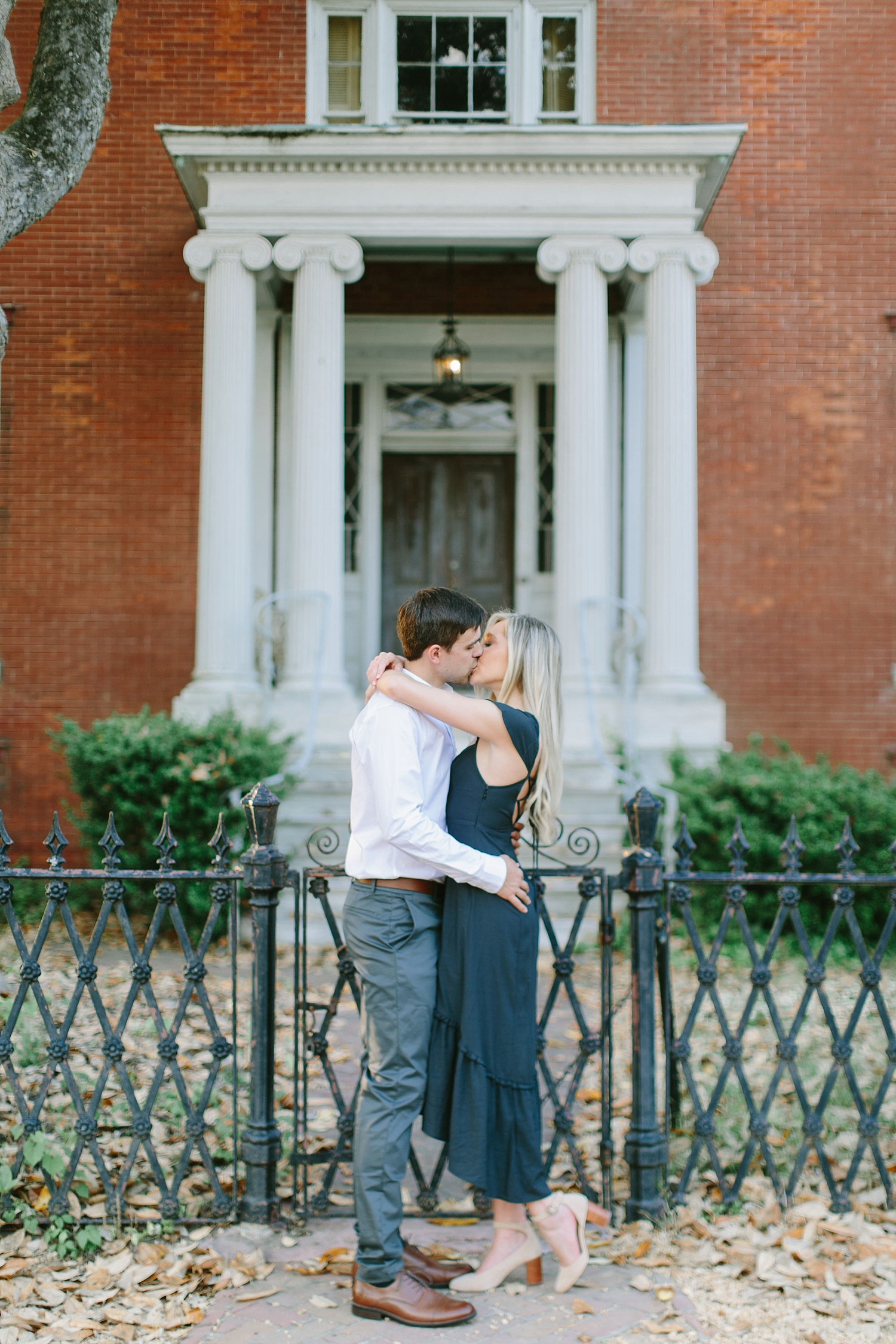 Couple kissing in front of historic building in Colonial Williamsburg