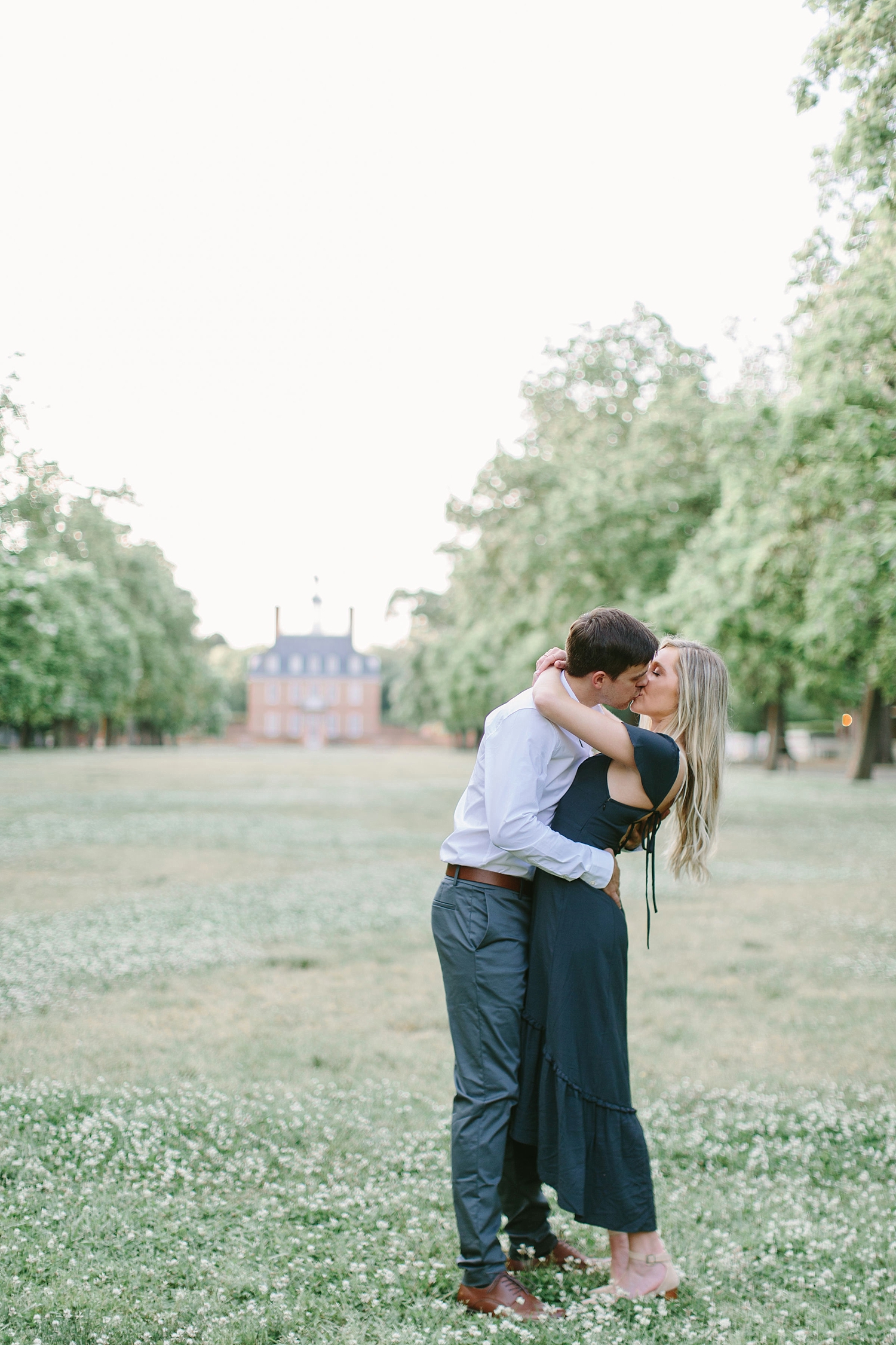 engagement photo of couple kissing in front of governor's mansion in Colonial Williamsburg